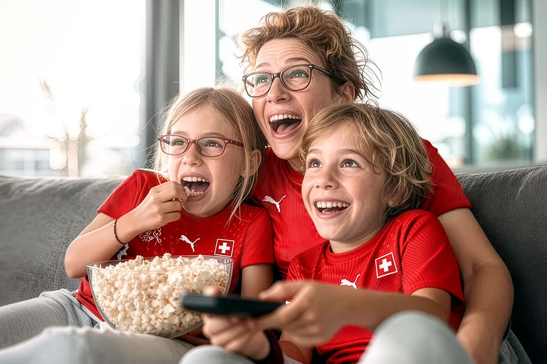 Familie mit Trikots auf Couch